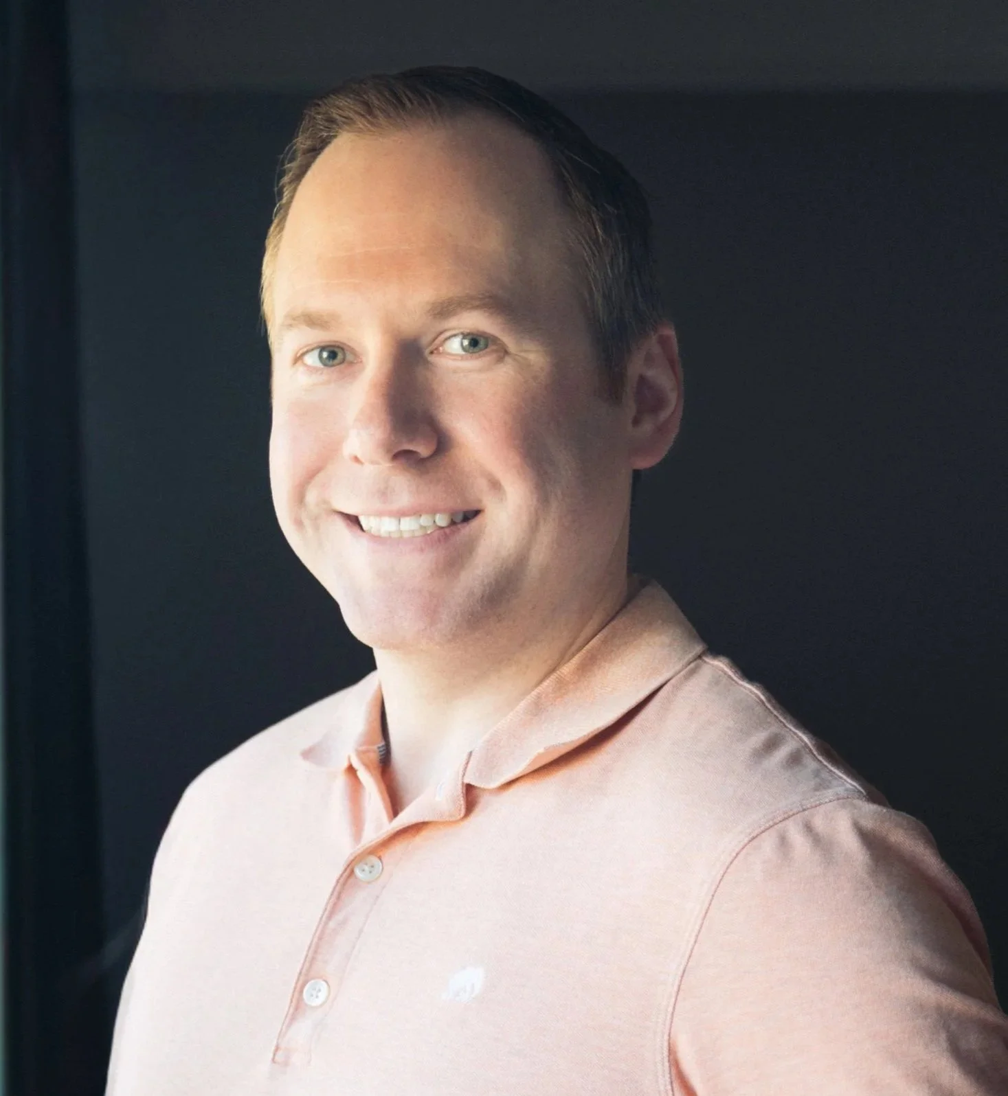 Steve Koch, smiling in a peach button-up shirt